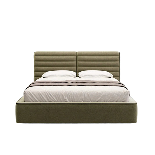 An upholstered bed frame in an olive green fabric, featuring a tall, segmented headboard and a matching low platform base, styled with white bedding and pillows against a light gray background.