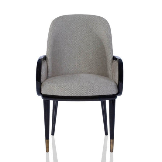 A mid-century modern accent chair featuring a light beige textured fabric upholstery and a glossy black frame with tapered legs and brass-colored tips, shown against a plain white background.